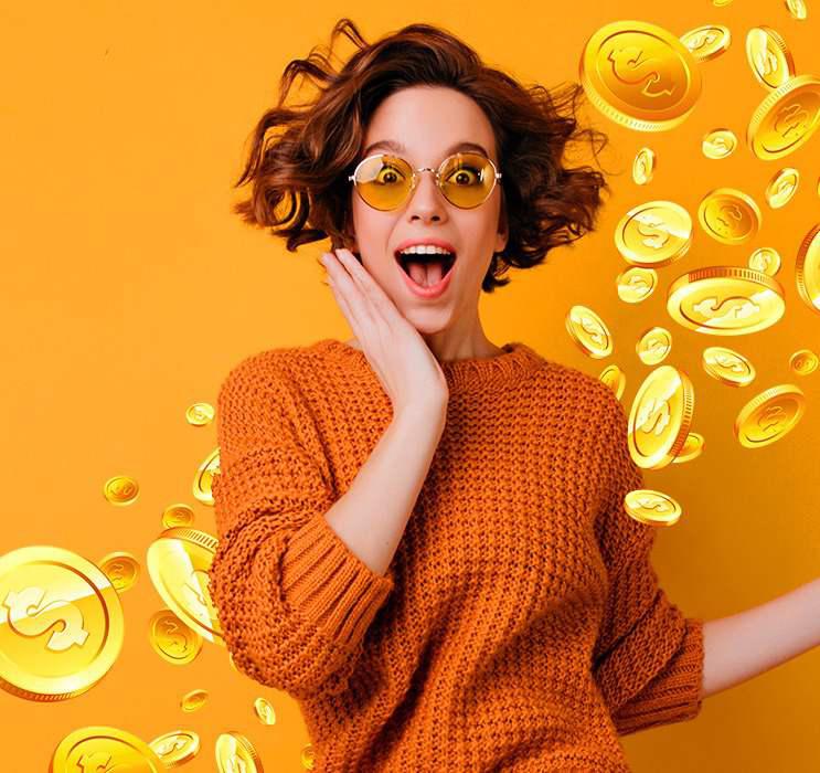 Happy female Keno player holding face in awe with gold coins falling in orange background